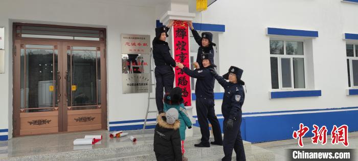 圖為恩和哈達邊境派出所民警貼對聯?！《骱凸_邊境派出所供圖